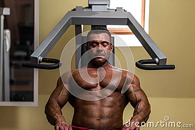 Bodybuilder resting after doing heavy weight exercise Stock Photo