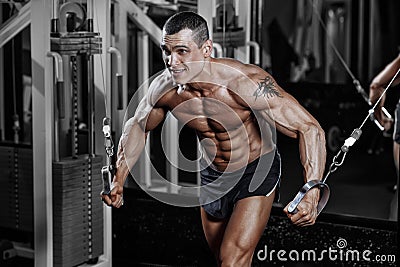 Bodybuilder training chest on simulator in the gym Stock Photo