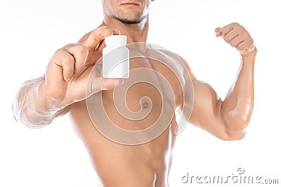 Bodybuilding and chemical additives: handsome strong bodybuilder holding a white jar of pills on white isolated background in stud Stock Photo