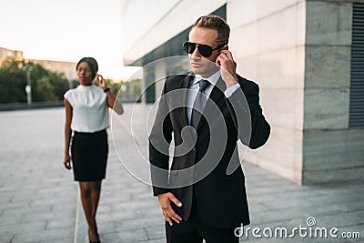 Bodyguard in sunglasses and black business woman Stock Photo