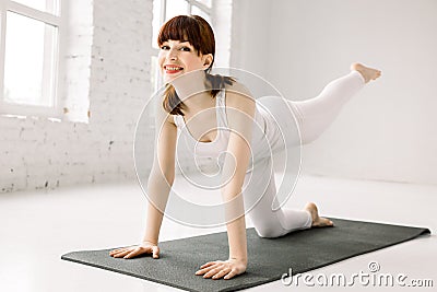 Bodyweight exercises - fitness woman doing fire hydrants legs kickbacks. Active girl training glute muscles raising one Stock Photo