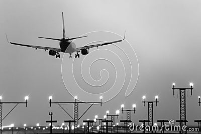 Boeing 767 landing with runway lights on. Stock Photo