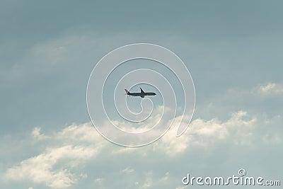 an airplane flying during sunset golden hour with blue cloudy sky Editorial Stock Photo