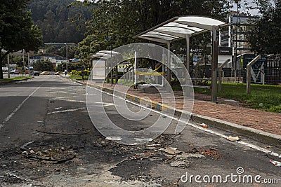 Bus stop destroy and burn pavement with a lot of rocks is the result of disturbs between protesters and colombian police riot Editorial Stock Photo
