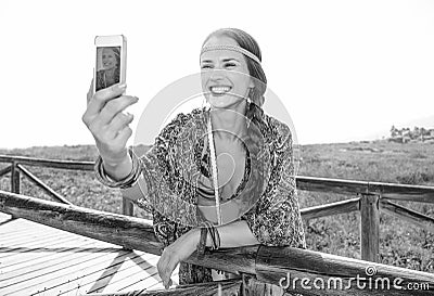 Happy fashion boho girl outdoors with smartphone taking selfie Stock Photo