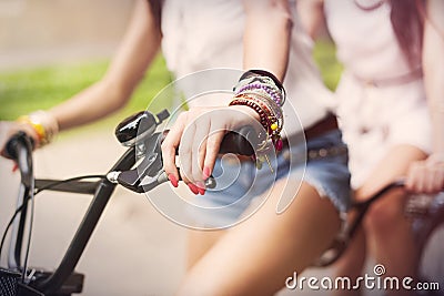 Boho girls riding on bike Stock Photo