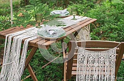 Boho style wedding reception dinning table with macrame tablecloth Stock Photo