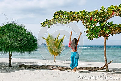 Boho styled young woman walking on the beach Stock Photo