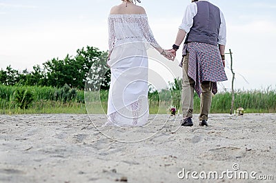 Boho wedding couple. Back view. Stylish hippie woman in white ethnic dress Stock Photo