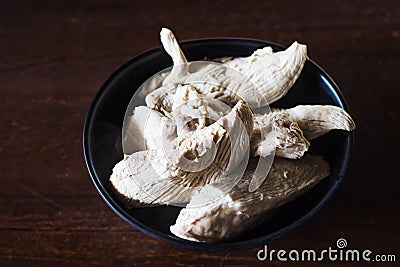 Boiled chicken breast in a black cup on a wooden table. Boiled chicken breast with high protein content Suitable for bodybuilders. Stock Photo