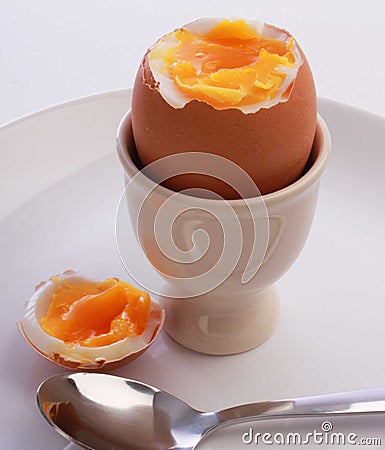Boiled egg,cut open in eggcup,on plate with spoon Stock Photo