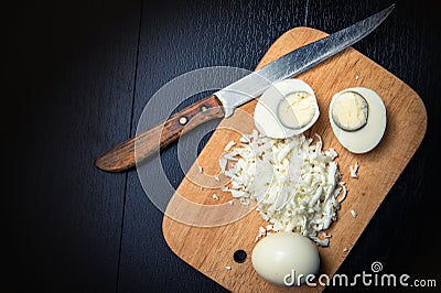 Boiled egg on a cutting board witn knife Stock Photo