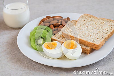 Boiled egg, whole wheat bread, kiwi, almonds and milk , Healthy food Stock Photo