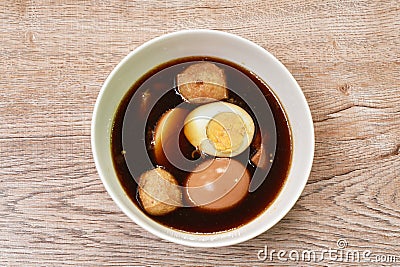 Boiled half cut egg with tofu in herb brown soup on bowl Stock Photo