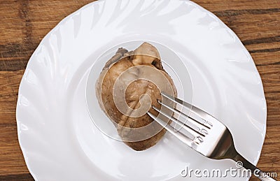 Boiled lamb heart on white plate on wooden background Stock Photo