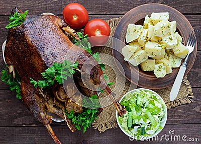 Boiled potatoes in a clay bowl, baked goose and cabbage salad. Stock Photo