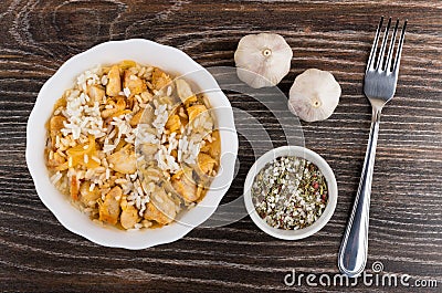 Boiled rice with chicken meat in bowl, garlic, spices Stock Photo