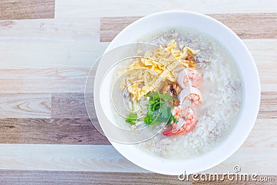 Boiled rice with pork was added on top with chopped omelet, boiled shrimp and coriander as a a breakfast meal in the morning in Stock Photo