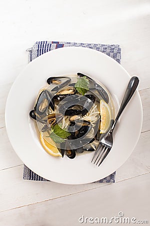 Boiled scottish mussels in a deep dish with parsley and lemon Stock Photo