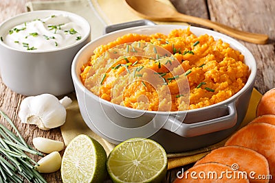 Boiled sweet potato with herbs, garlic and lime closeup in a saucepan. horizontal Stock Photo