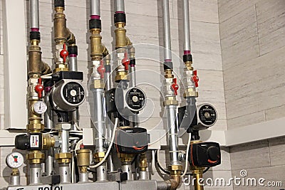 Heating of the house with a large number of steel pipes, pressure gauges and metal pipes, selective focus. Boiler and pipes of the Editorial Stock Photo