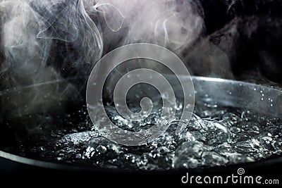 Boiling pot of water with steam Stock Photo