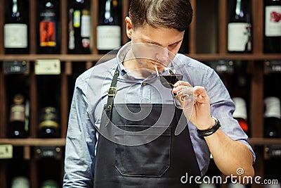 Bokal of red wine on background, male sommelier appreciating drink Stock Photo