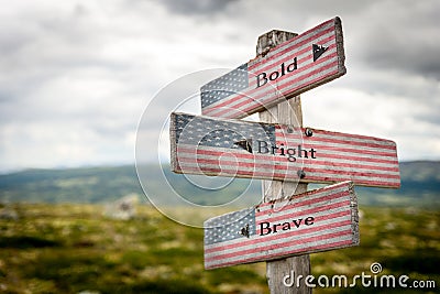 Bold bright and brave text on wooden american flag signpost outdoors Stock Photo