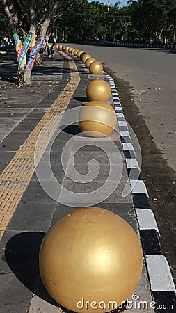 bollard ball barrier between road and sidewalk part of street furniture as a road divider to protect pedestrians Stock Photo