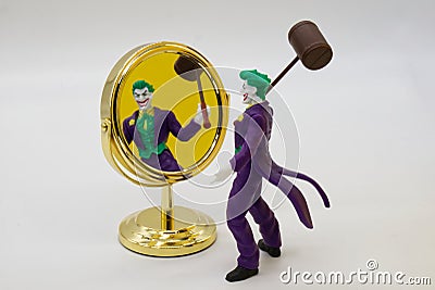 The Joker miniature looks at himself in the mirror. Joker from DC comics Editorial Stock Photo