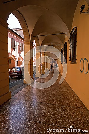 BOLOGNA, ITALY - MAY 03, 2016: Yellow walls of Portico, sheltered walkway in the streets of Bologna, Emilia-Romagna, Italy Editorial Stock Photo