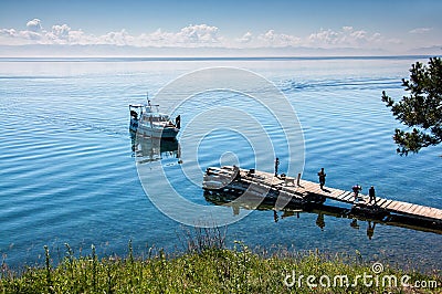 Bolshiye Koti, RUSSIA - JULY 18: macrophototour, members of team are waiting boat and taking pictures near lake Baikal Editorial Stock Photo