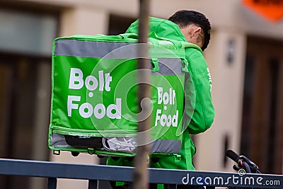 Bolt Food company food delivery worker with food delivery box. Editorial Stock Photo