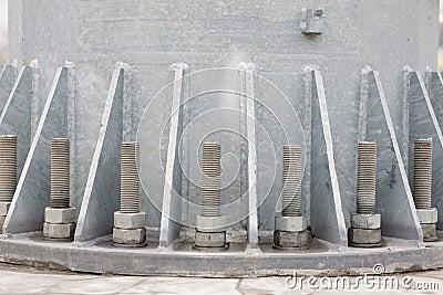 Bolts and nuts on a steel plate. Several bolts are firmly fixed on the metal base of the column to the concrete column Stock Photo