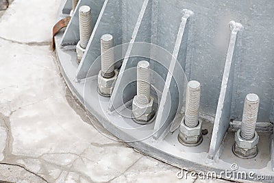 Bolts and nuts on a steel plate. Several bolts are firmly fixed on the metal base of the column to the concrete column Stock Photo