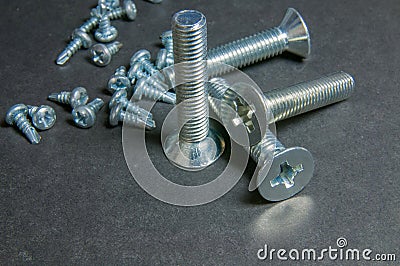 Bolts and Screws on grey. Centre upright bolt Stock Photo