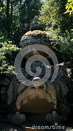 Monstrous sculpture called of Proteus and Glaucus at the Park of the Monsters of Bomarzo among trees and vegetation Editorial Stock Photo