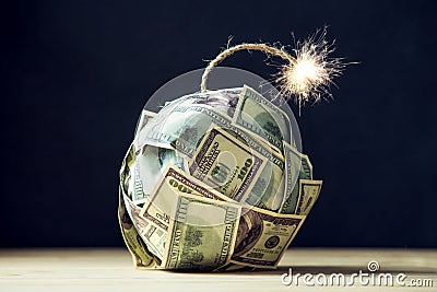 Bomb of money hundred dollar bills with a burning wick. Little time before the explosion. Concept of financial crisis Stock Photo