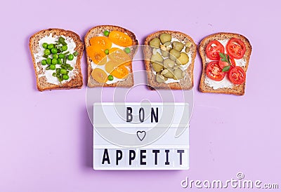 Bon appetite lettering with vegetarian vegetable sandwiches with cream cheese on purple background Stock Photo