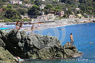 Bonassola, Italy - summer2020: guys dive from a cliff into the sea of the five lands Editorial Stock Photo