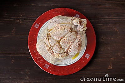 Bondage shibari oiled and spiced raw chicken on red boarder plat Stock Photo