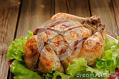 Bondage shibari roasted chicken with salad leaves on red plate o Stock Photo