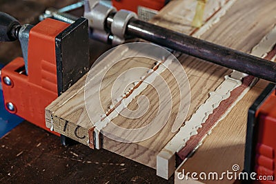 Bonding wood in the workshop. The use of glue for different types of wood. Making worktops for the kitchen. Work as a Stock Photo