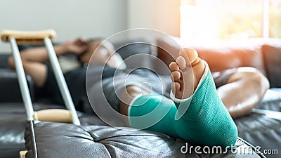 Bone fracture foot and leg on male patient with splint cast and crutches during surgery rehabilitation and orthopaedic recovery Stock Photo