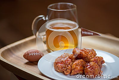 Boneless hot wings on plate with glass mug of beer and football Stock Photo
