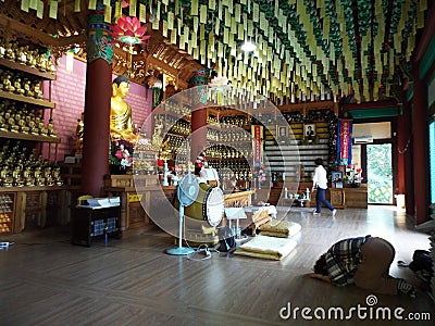 A woman prays inside a temple in Bongha Village, the birthplace of Roh Moo-hyun, 16th President of South Korea Editorial Stock Photo