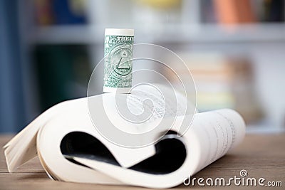 A book and a roll of dollar bills Stock Photo