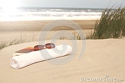 Book sunglasses towel on a beach Stock Photo