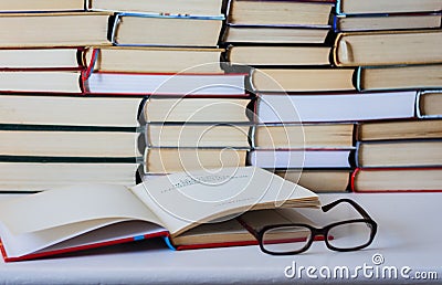 Book, textbook and glasses in library, stack piles of literature text archive, bookshelves in school study class room background f Stock Photo