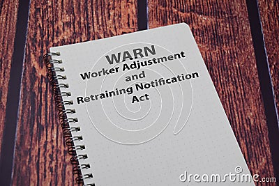 Book about WARN - Worker Adjustment & Retraining Notification Act isolated on wooden table Stock Photo